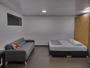 a bedroom with a bed and a couch at Casa en el campo - villeta in Villeta +9 photos
