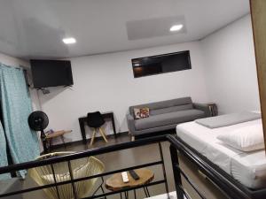 a living room with a bed and a couch at Casa en el campo - villeta in Villeta