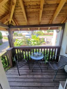 a patio with two chairs and a table on a deck at Gościniec Joanna in Rajgród