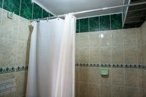 a shower with a white shower curtain in a bathroom at Luz y Amistad - Pisac in Pisac +49 photos