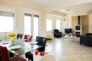 a living room with a glass table and chairs at Zeusplace Anamesa Pool Villa in Litochoro