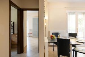 a dining room and living room with a table and chairs at Zeusplace Anamesa Pool Villa in Litochoro