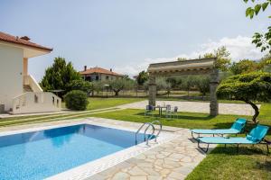 a swimming pool in a yard next to a house at Zeusplace Anamesa Pool Villa in Litochoro