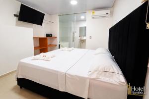 a bedroom with a large white bed with a mirror at Hotel Bambù 2 in Puerto Asís +27 photos