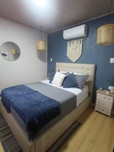 a bedroom with a bed with a blue wall at Alma Libre 01 in Fortuna