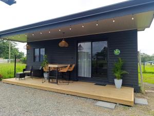 a black house with a wooden deck with a table at Alma Libre 01 in Fortuna