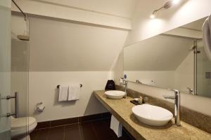 a bathroom with two sinks and a mirror at Hotel bh La Quinta in Bogotá