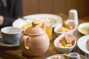 a table with a tea pot and bowls of food at Hotel bh La Quinta in Bogotá +24 photos