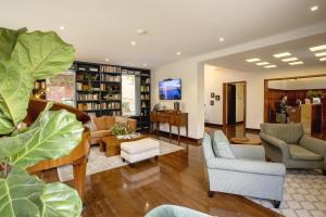 a living room with couches and chairs and a tv at Hotel bh La Quinta in Bogotá