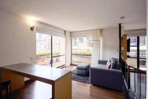 a living room with a couch and a table at Hotel bh La Quinta in Bogotá