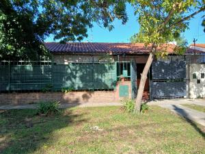 a house with a fence and a tree at Casa amigable dos habitaciones cuatro lugares in Rosario