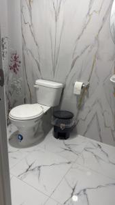 a bathroom with a toilet and marble walls at Hostal Paraíso Vip in Portoviejo