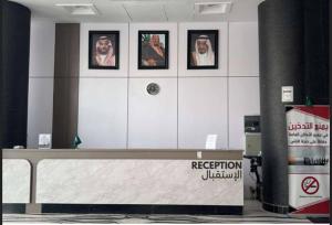 a room with white cabinets with pictures on the wall at شعيل ان للشقق المخدومة - اقتصادي in Mecca
