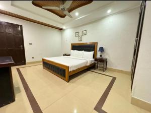 a bedroom with a bed and a table in a room at Comfort Guest House in Karachi