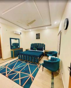 a living room with blue furniture and blue chairs at Comfort Guest House in Karachi