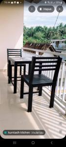 a black bench and a table on a balcony at Luchis HOME Ijen in Banyuwangi