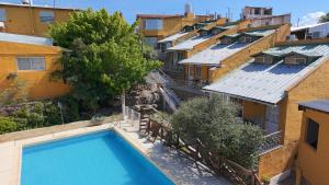 an overhead view of a swimming pool between buildings at Complejo El Alto in Tanti