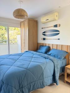 a bedroom with a blue bed and a fan at Casa GERIBÁ in Búzios +25 photos