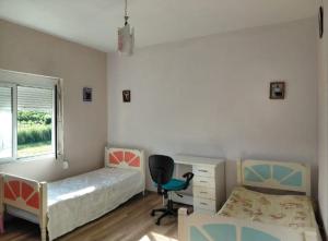 a bedroom with two beds and a desk and a chair at Family-friendly in Pogradec