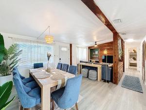 a dining room with a table and blue chairs at Modern 3BR Retreat with Pool & Fire Pit in Largo