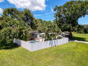 a white fence in a yard with trees at Modern 3BR Retreat with Pool & Fire Pit in Largo