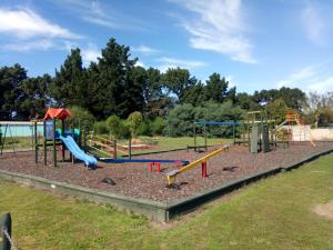 a park with a playground with a slide at Leithfield Beach Holiday Park in Leithfield