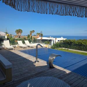 a swimming pool with chairs and the ocean in the background at Casa Azul in Luz