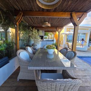 a patio with a table and wicker chairs at Casa Azul in Luz