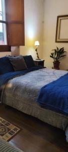 a bedroom with a large bed with a blue blanket at Pueblo Nómade in Tranqueras