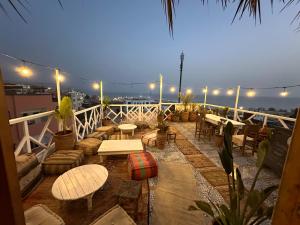 a patio with tables and chairs on a balcony at night at West coast surf house in Imsouane