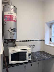 a microwave sitting on a counter in a kitchen at Lomar Apart 2 - Depto céntrico Villa María in Villa María