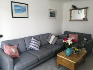 un soggiorno con un divano grigio e un tavolo di Riverbella a Looe