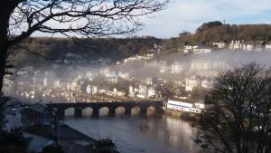 un ponte su un fiume con una città sullo sfondo di Riverbella a Looe