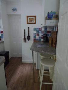 una cucina con bancone, tavolo e sedie di Riverbella a Looe