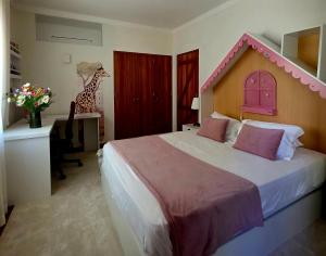 a bedroom with a bed with a toy giraffe on it at Casa Azul in Luz +76 photos