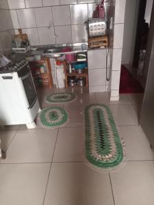 a kitchen with three green rugs on the floor at Leandra in Ponta Porã