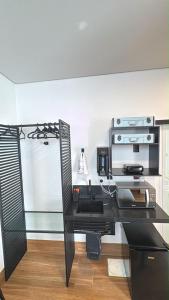 a office with a black desk with a coffee maker at 1Studio ao lado da Praça Augusto Silva, PRÓXIMO À UFLA E UNILAVRAS in Lavras