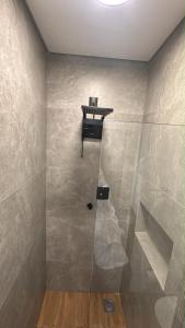 a bathroom with a shower with a shelf on the wall at 1Studio ao lado da Praça Augusto Silva, PRÓXIMO À UFLA E UNILAVRAS in Lavras