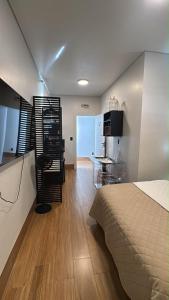 a bedroom with a bed and a kitchen with a table at 2Studio no centro, aconchegante no coração da cidade, UFLA - UNILAVRAS in Lavras