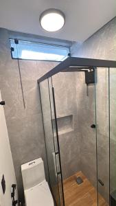 a bathroom with a toilet and a glass shower at 2Studio no centro, aconchegante no coração da cidade, UFLA - UNILAVRAS in Lavras