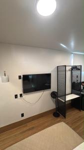 a living room with a flat screen tv on a wall at 2Studio no centro, aconchegante no coração da cidade, UFLA - UNILAVRAS in Lavras