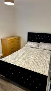 a bedroom with a bed and a wooden dresser at HomesRentals in Dudley