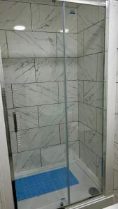 a shower with white marble walls in a bathroom at HomesRentals in Dudley