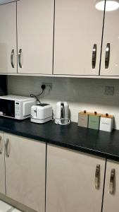 a kitchen counter with a microwave and appliances on it at HomesRentals in Dudley +13 photos