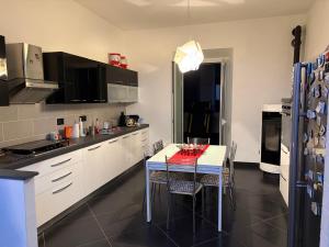 a kitchen with a table with chairs and a refrigerator at Casa Giulia in Taviano