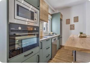 eine Küche mit einem Edelstahlofen und einem Holztisch in der Unterkunft Estudio Key in Icod de los Vinos + 13 Fotos