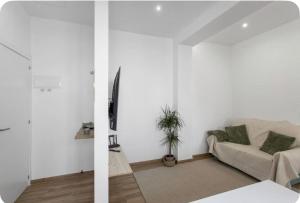ein Wohnzimmer mit weißen Wänden und einem Sofa in der Unterkunft Estudio Key in Icod de los Vinos