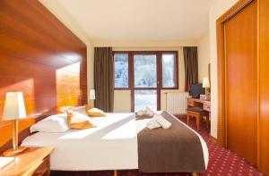 a hotel room with a large bed and a desk at Belambra terra nova in La Plagne Tarentaise