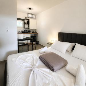 a bedroom with a white bed with a bow on it at Coconut Beach Villas 3 in Schinias