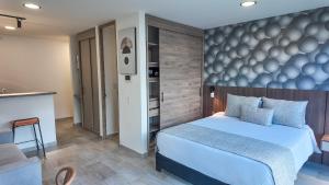 a bedroom with a large bed and a kitchen at Hotel Molinos by Growing Group in Medellín